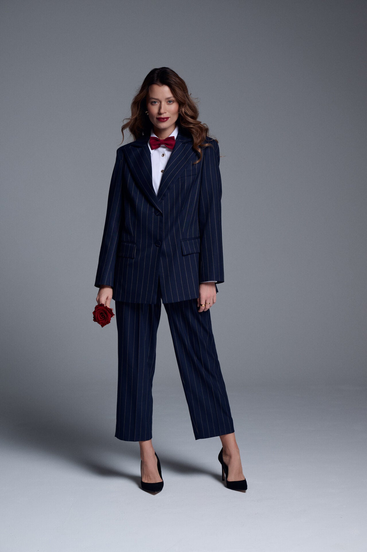 Stylizacja retro z granatowymi spodniami cygaretkami i marynarką – kobiecy garnitur w nowoczesnym wydaniu, idealny na ważne spotkania i formalne okazje.