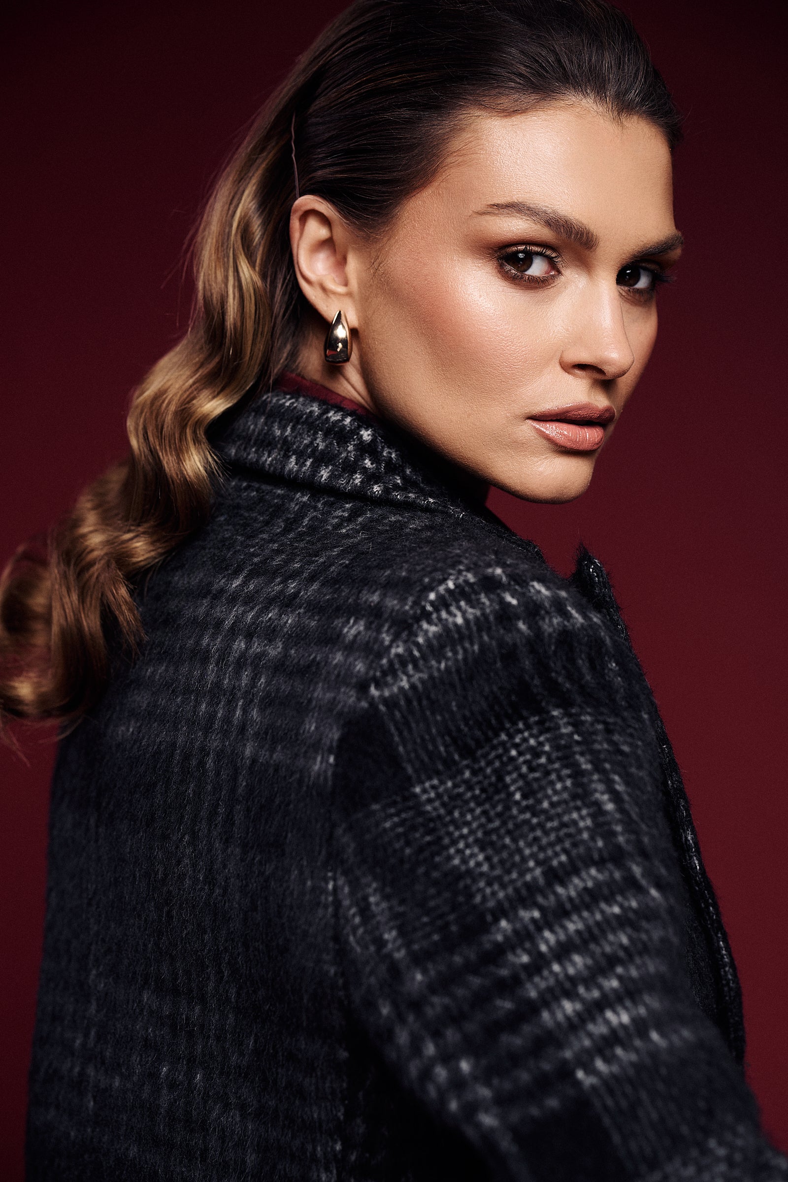 Portret w stylu glamour z wełnianą kurtką w kratę – wyrazisty look premium, idealny na wyjątkowe okazje.
