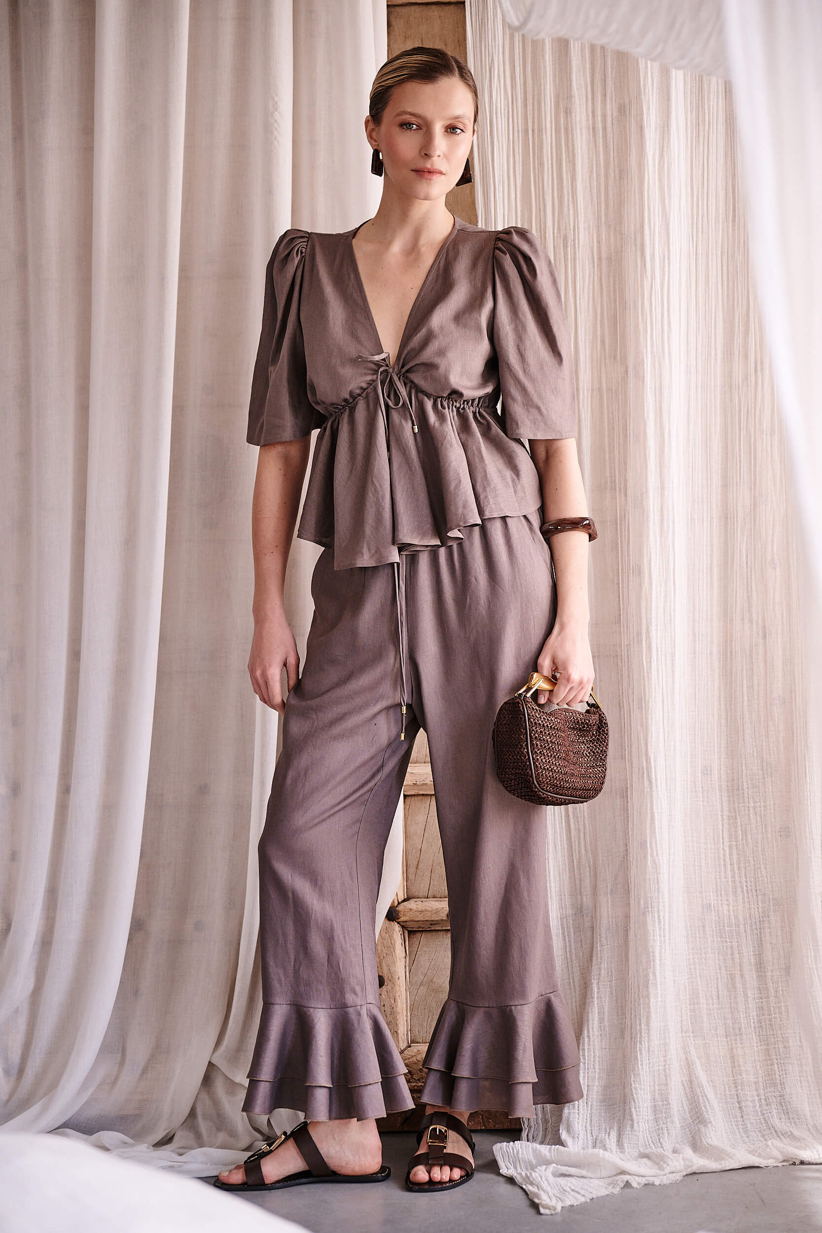 Stylowe spodnie z lnu od Anny Markowskiej – wysoki stan, elastyczna talia i ozdobna falbana.