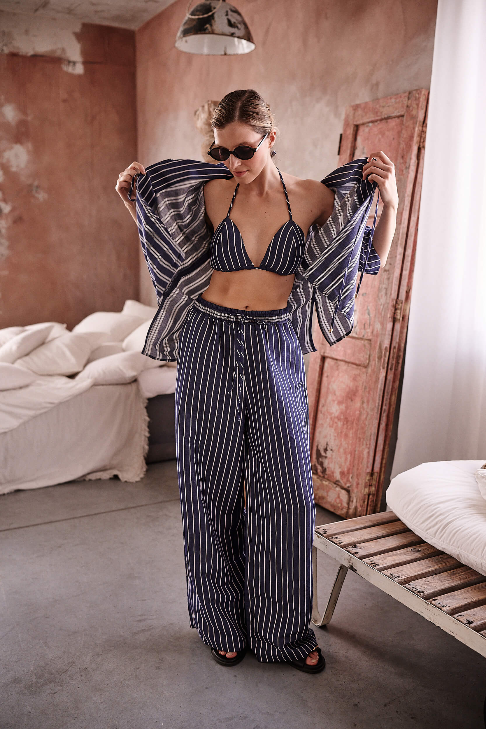 Lniany komplet w granatowe paski: bikini, koszula i spodnie od Aleksandry Markowskiej – swobodna stylizacja z wakacyjnym charakterem.