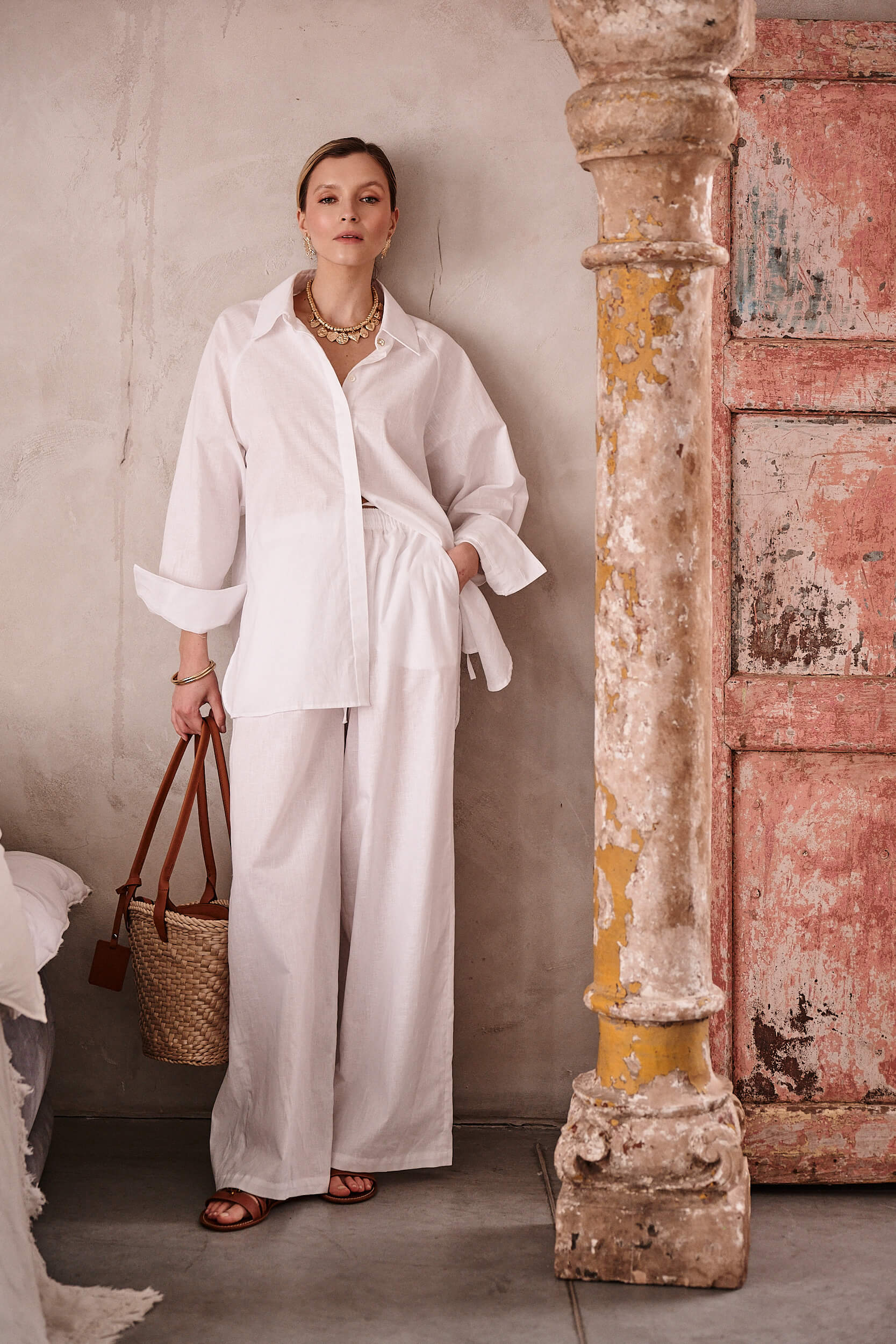 Spodnie Levante Luce z białego lnu – luźna nogawka i troczek w talii, zestawione z koszulą z tej samej kolekcji autorstwa Aleksandry Markowskiej.