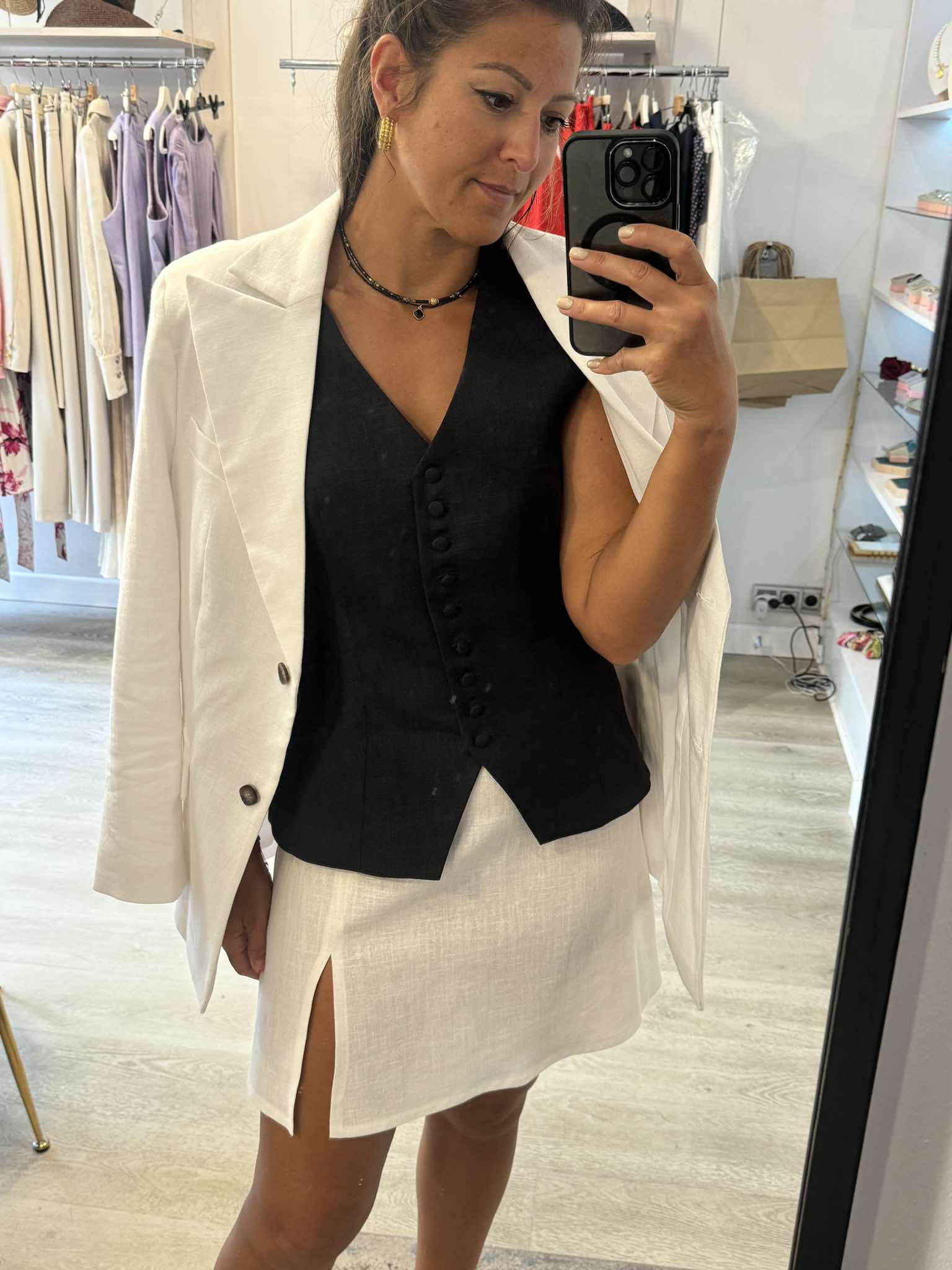 Modelka w białej spódnicy Palermo Bianco i czarnej kamizelce – kontrastowa, elegancka stylizacja na słoneczne dni