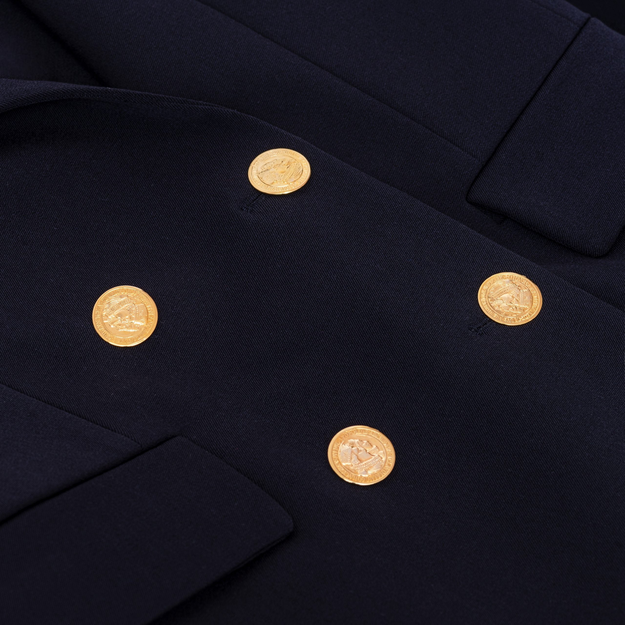 Aleksandra Markowska i zbliżenie na złote guziki w granatowej marynarce, luksusowy detal w stylu klasycznej mody premium.