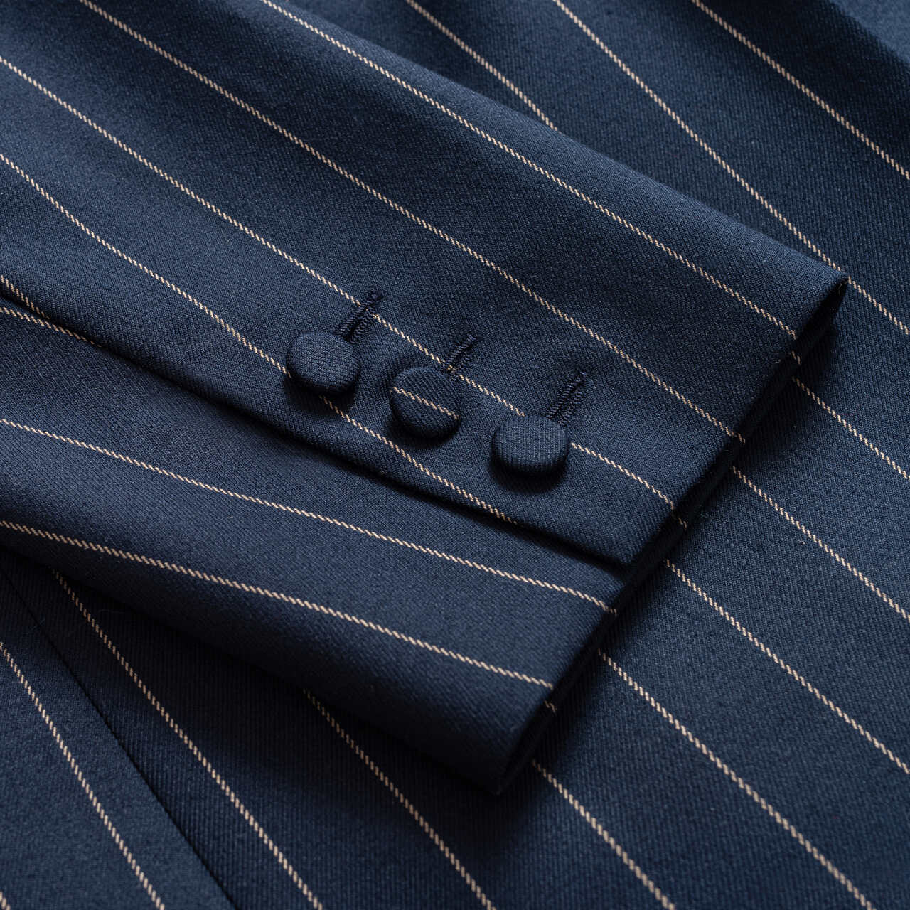 Zbliżenie na guziki i fakturę eleganckiej, granatowej marynarki w stylu power dressing i modern classic od Aleksandry Markowskiej.