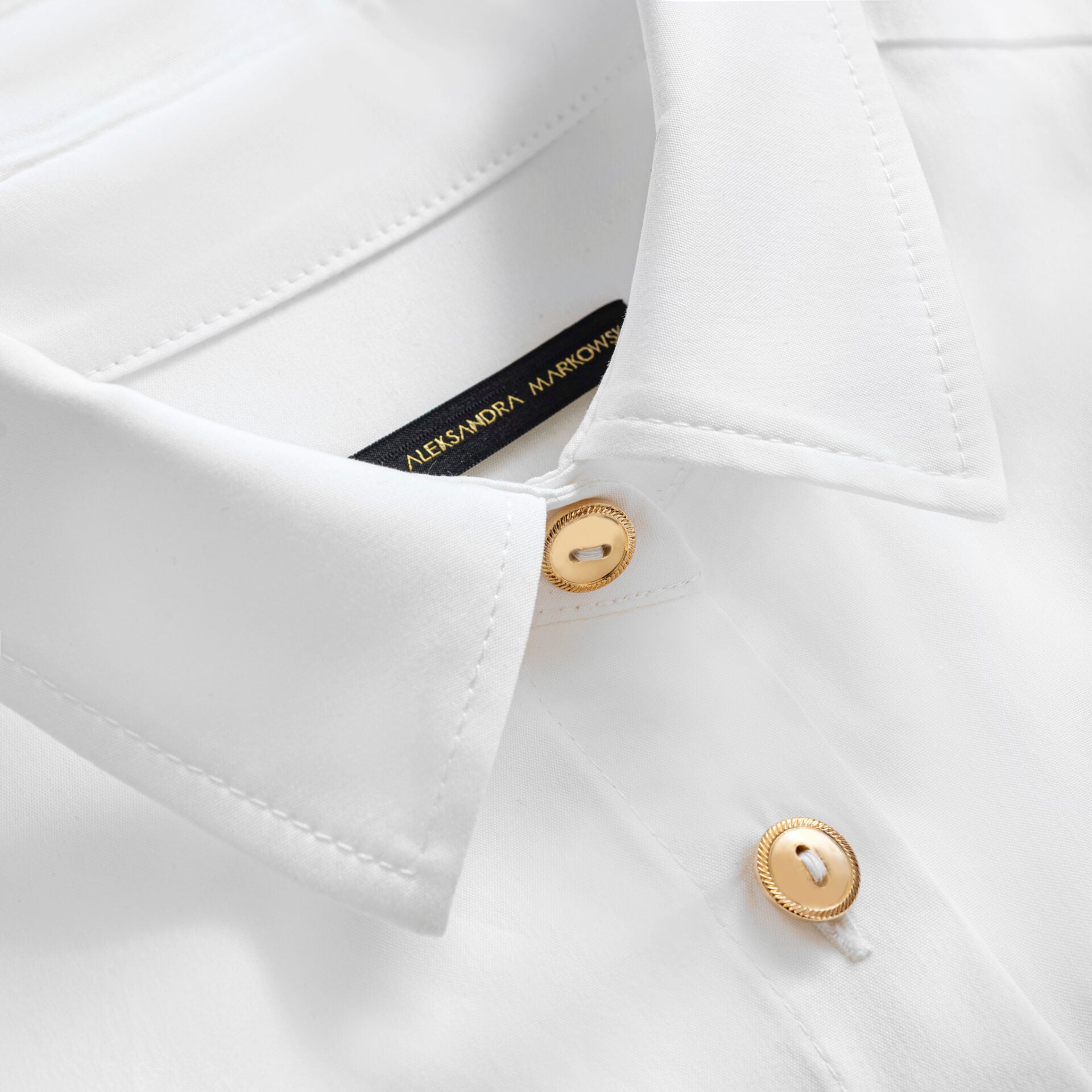 Kołnierz damskiej koszuli z bawełny z minimalistycznym guzikiem od Aleksandry Markowskiej.