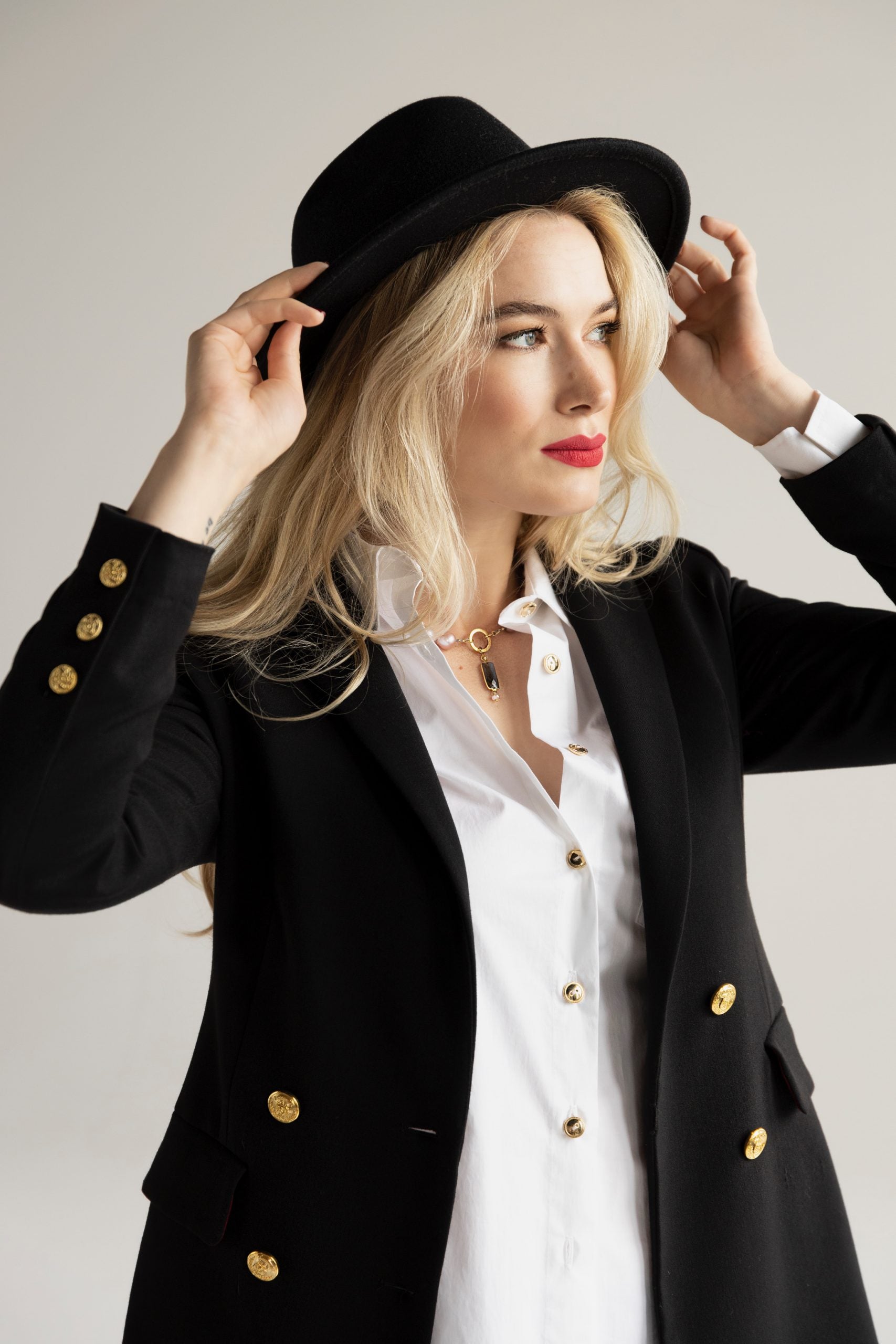 Kobieta w granatowej marynarce i kapeluszu, stylizacja inspirowana klasyką i francuskim szykiem od Aleksandry Markowskiej.