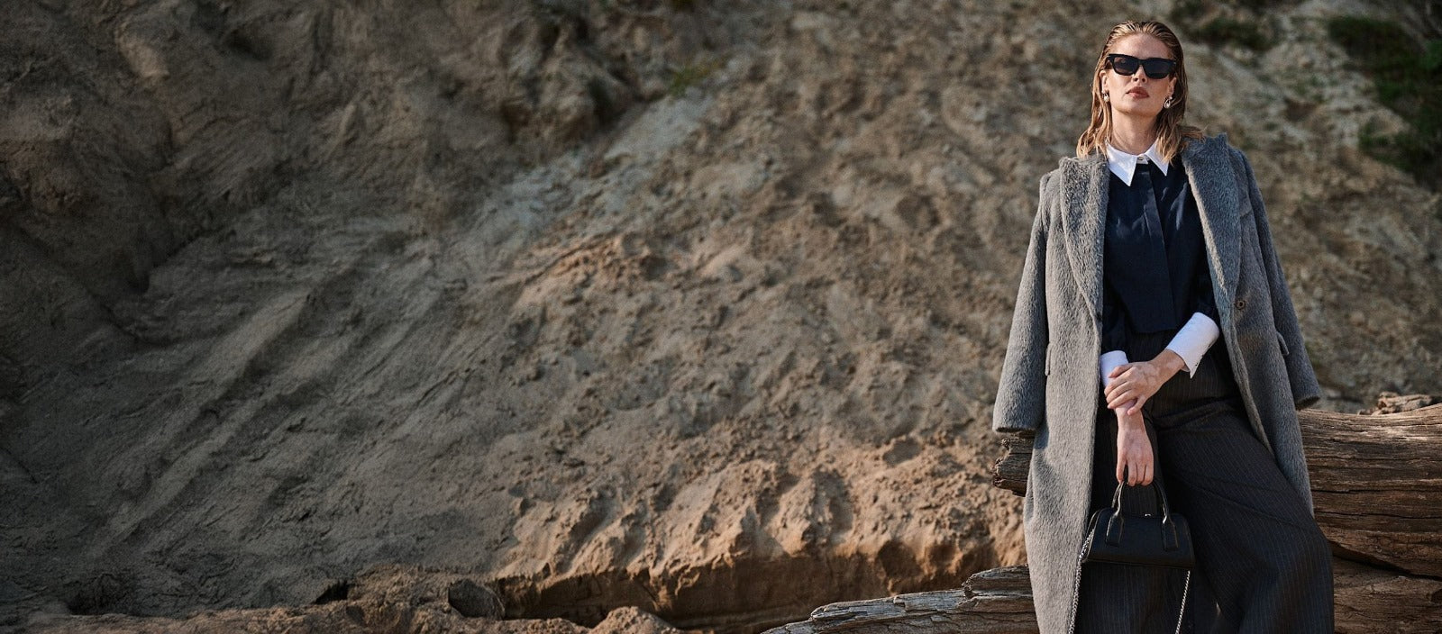 Kobieta w szarym płaszczu z wełny premium i czarnej stylizacji od Aleksandry Markowskiej, jesienna kolekcja odzieżowa.