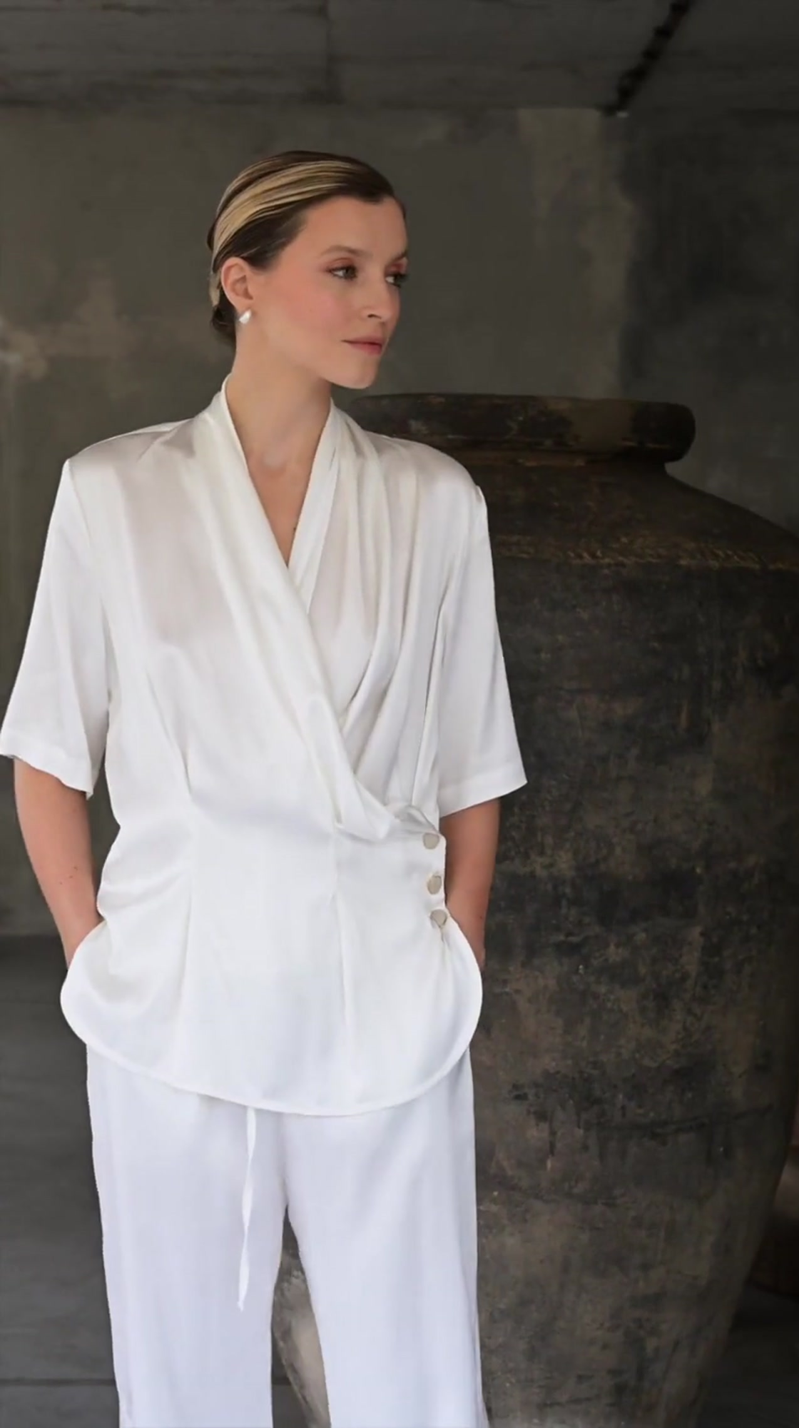 Film prezentujący spodnie Serena Bianca od Aleksandry Markowskiej – elegancki, biały model z lekkiej wiskozy o fasonie wide leg. Elastyczna talia i subtelny połysk tkaniny podkreślają letni charakter stylizacji. Idealne w zestawie z koszulą Serena Bianca, ale również solo – z topem lub marynarką – na wakacje, spotkanie lub garden party.