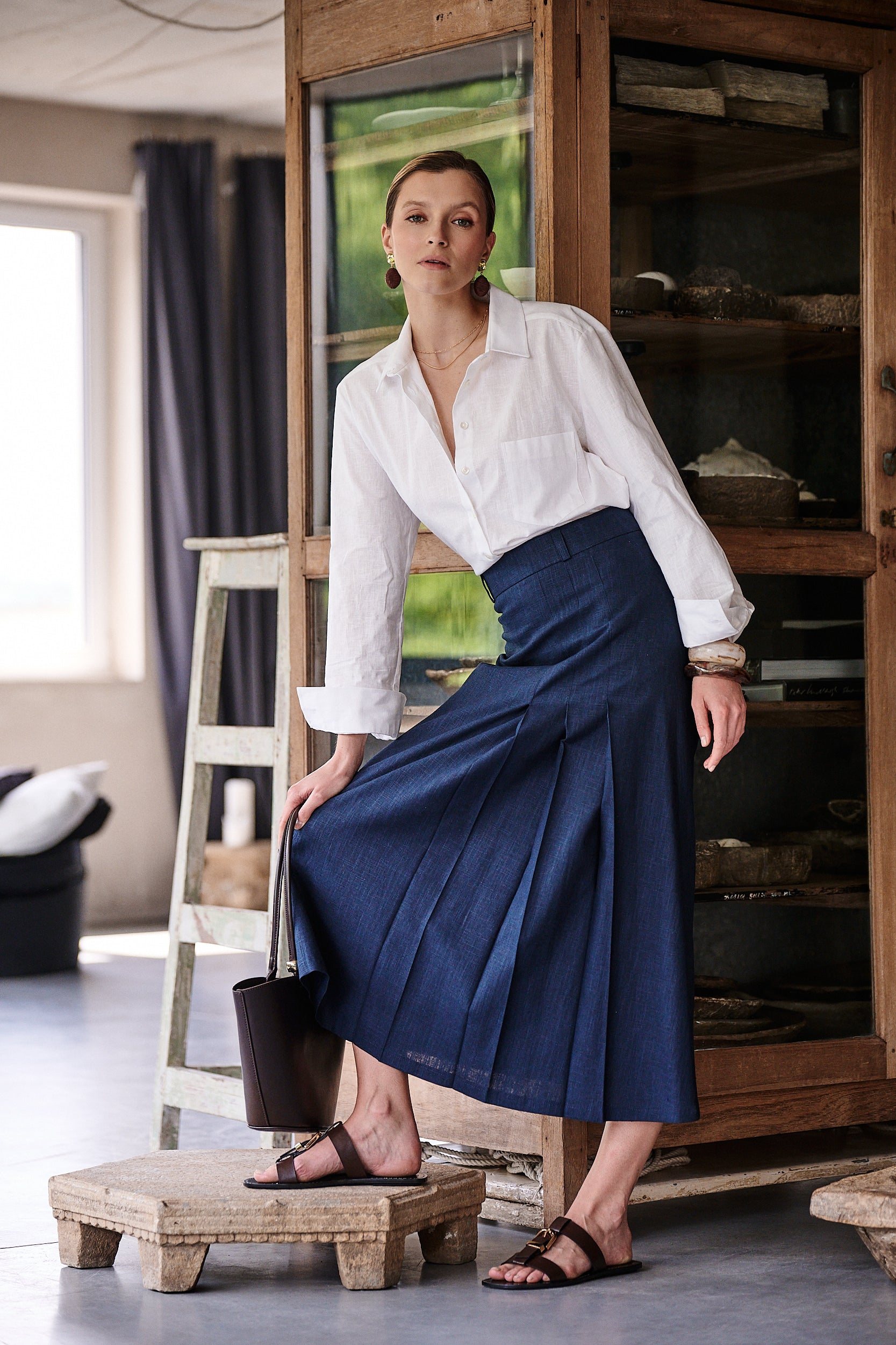 Granatowa lniana spódnica Palermo Blu Marina od Aleksandry Markowskiej w stylizacji z białą koszulą – elegancki, codzienny look idealny na lato, prezentujący kontrafałdę i lekkość formy.